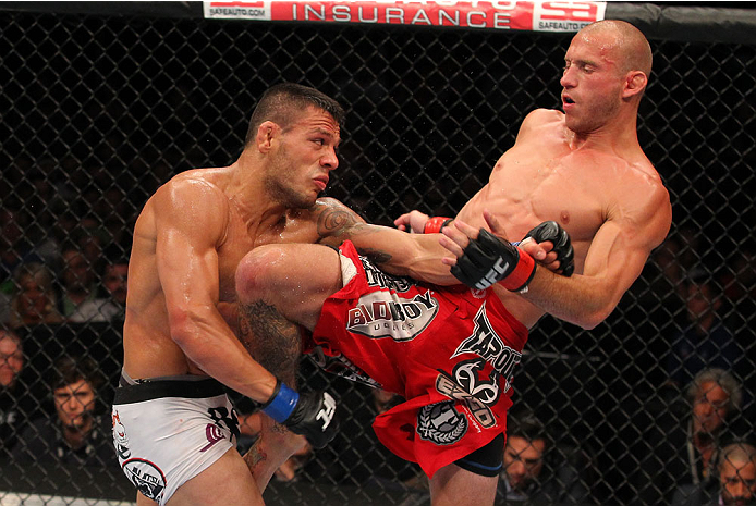 INDIANAPOLIS, IN - AUGUST 28: (R-L) Donald "Cowboy" Cerrone knees Rafael dos Anjos in their lightweight fight during the UFC on FOX Sports 1 event at Bankers Life Fieldhouse on August 28, 2013 in Indianapolis, Indiana. (Photo by Ed Mulholland/Zuffa LLC/Z