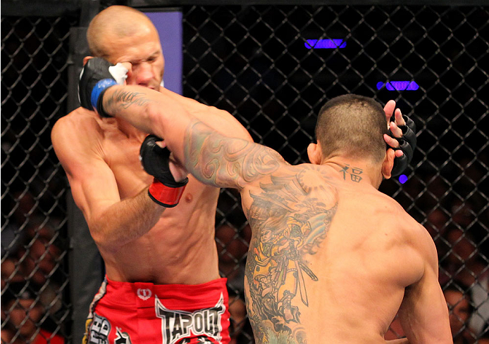 INDIANAPOLIS, IN - AUGUST 28: (R-L) Rafael dos Anjos punches Donald "Cowboy" Cerrone in their lightweight fight during the UFC on FOX Sports 1 event at Bankers Life Fieldhouse on August 28, 2013 in Indianapolis, Indiana. (Photo by Ed Mulholland/Zuffa LLC