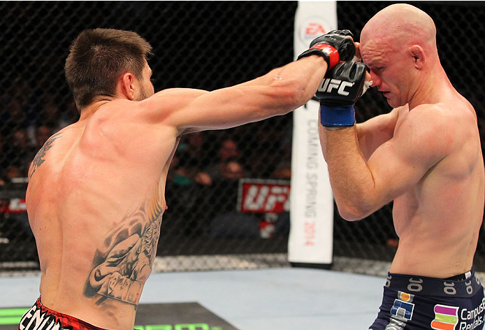 INDIANAPOLIS, IN - AUGUST 28: (L-R) Carlos Condit punches Martin Kampmann in their welterweight fight during the UFC on FOX Sports 1 event at Bankers Life Fieldhouse on August 28, 2013 in Indianapolis, Indiana. (Photo by Ed Mulholland/Zuffa LLC/Zuffa LLC