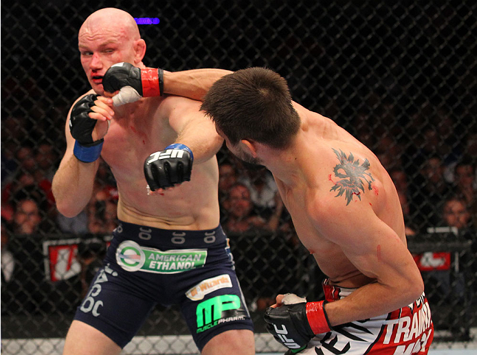 INDIANAPOLIS, IN - AUGUST 28: (R-L) Carlos Condit punches Martin Kampmann in their welterweight fight during the UFC on FOX Sports 1 event at Bankers Life Fieldhouse on August 28, 2013 in Indianapolis, Indiana. (Photo by Ed Mulholland/Zuffa LLC/Zuffa LLC