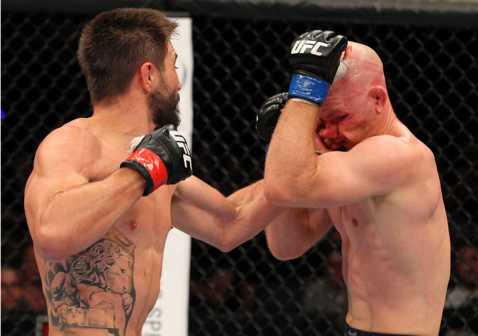 INDIANAPOLIS, IN - AUGUST 28: (L-R) Carlos Condit punches Martin Kampmann in their welterweight fight during the UFC on FOX Sports 1 event at Bankers Life Fieldhouse on August 28, 2013 in Indianapolis, Indiana. (Photo by Ed Mulholland/Zuffa LLC/Zuffa LLC
