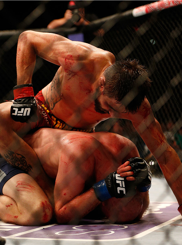 INDIANAPOLIS, IN - AUGUST 28: (L-R) Carlos Condit punches Martin Kampmann in their welterweight fight during the UFC on FOX Sports 1 event at Bankers Life Fieldhouse on August 28, 2013 in Indianapolis, Indiana. (Photo by Josh Hedges/Zuffa LLC/Zuffa LLC v