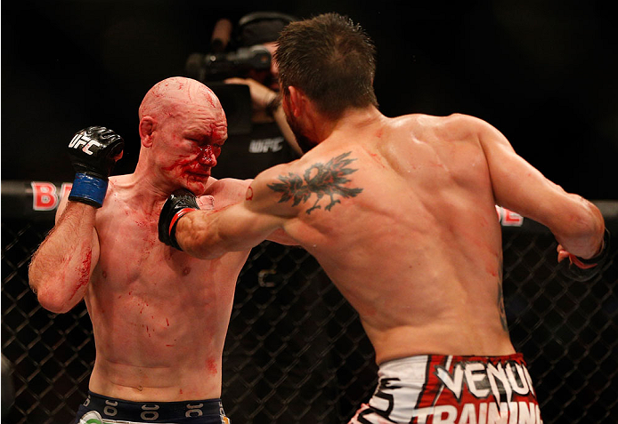 INDIANAPOLIS, IN - AUGUST 28: (R-L) Carlos Condit punches Martin Kampmann in their welterweight fight during the UFC on FOX Sports 1 event at Bankers Life Fieldhouse on August 28, 2013 in Indianapolis, Indiana. (Photo by Josh Hedges/Zuffa LLC/Zuffa LLC v