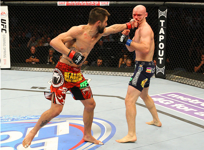 INDIANAPOLIS, IN - AUGUST 28: (L-R) Carlos Condit punches Martin Kampmann in their welterweight fight during the UFC on FOX Sports 1 event at Bankers Life Fieldhouse on August 28, 2013 in Indianapolis, Indiana. (Photo by Ed Mulholland/Zuffa LLC/Zuffa LLC