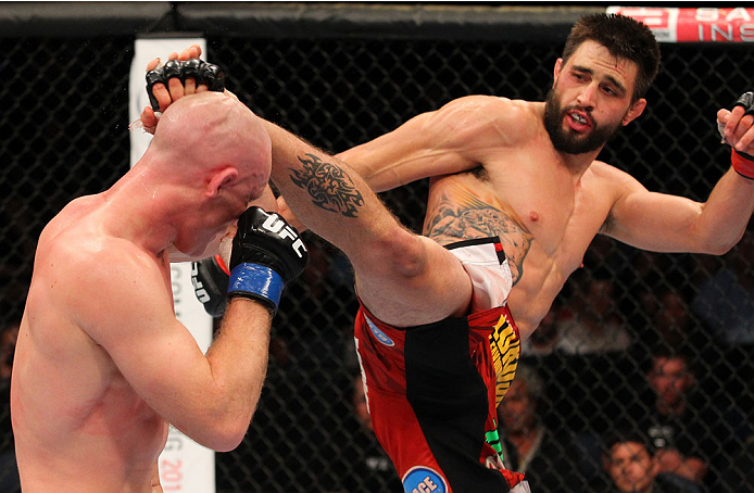 INDIANAPOLIS, IN - AUGUST 28: (R-L) Carlos Condit kicks Martin Kampmann in their welterweight fight during the UFC on FOX Sports 1 event at Bankers Life Fieldhouse on August 28, 2013 in Indianapolis, Indiana. (Photo by Ed Mulholland/Zuffa LLC/Zuffa LLC v