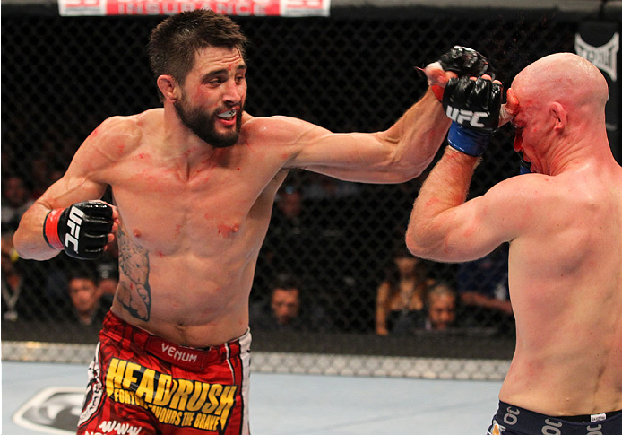 INDIANAPOLIS, IN - AUGUST 28: (L-R) Carlos Condit punches Martin Kampmann in their welterweight fight during the UFC on FOX Sports 1 event at Bankers Life Fieldhouse on August 28, 2013 in Indianapolis, Indiana. (Photo by Ed Mulholland/Zuffa LLC/Zuffa LLC