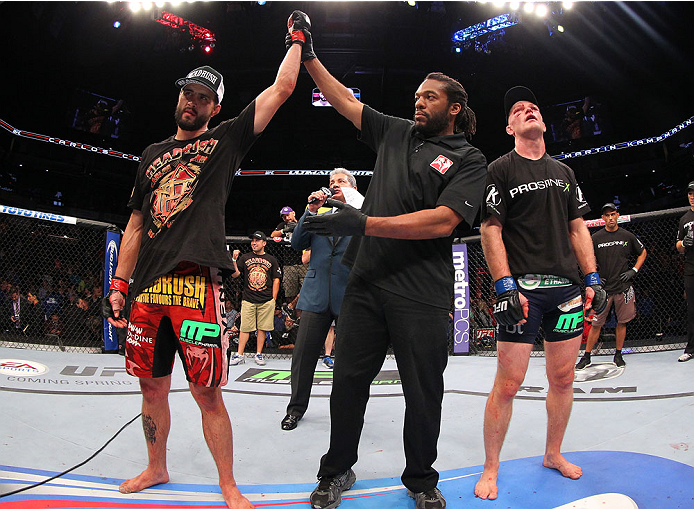 INDIANAPOLIS, IN - AUGUST 28: Carlos Condit (L) reacts after his TKO victory over Martin Kampmann in their welterweight fight during the UFC on FOX Sports 1 event at Bankers Life Fieldhouse on August 28, 2013 in Indianapolis, Indiana. (Photo by Ed Mulhol