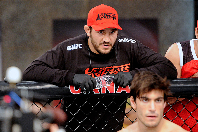 LACHUTE, CANADA - NOVEMBER 5: Team Canada Coach Patrick Cote stands above fighter Elias Theodorou before his middleweight bout against Team Australia fighter Zein Saliba during filming of The Ultimate Fighter Nations television series on November 5, 2013