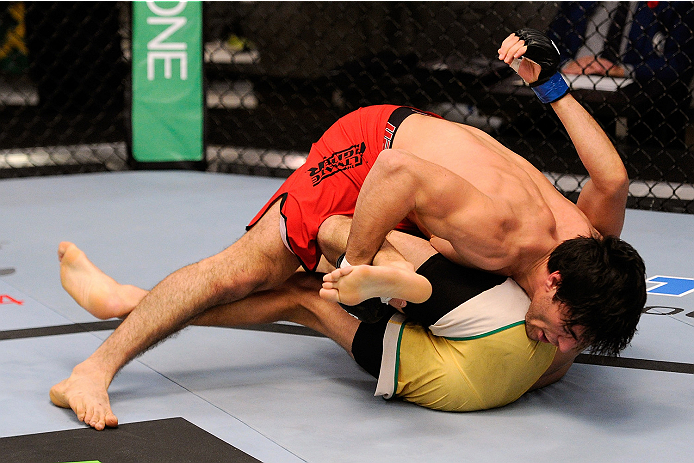 LACHUTE, CANADA - NOVEMBER 5: Team Canada fighter Elias Theodorou (red shorts) takes down Team Australia fighter Zein Saliba in their middleweight bout during filming of The Ultimate Fighter Nations television series on November 5, 2013 in Lachute, Quebe