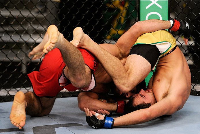 LACHUTE, CANADA - NOVEMBER 5: Team Canada fighter Elias Theodorou (red shorts) takes down Team Australia fighter Zein Saliba in their middleweight bout during filming of The Ultimate Fighter Nations television series on November 5, 2013 in Lachute, Quebe