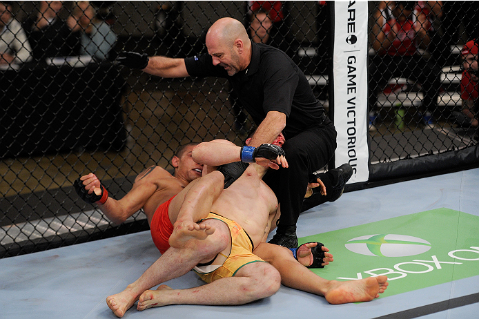 LACHUTE, CANADA - NOVEMBER 2: Referee Yves Lavigne (black shirt) stops the fight between Team Canada fighter Kajan Johnson (red shorts) and Team Australia fighter Brendan O'Reilly (green shorts) after Johnson submitted O'Reilly in their welterweight bout