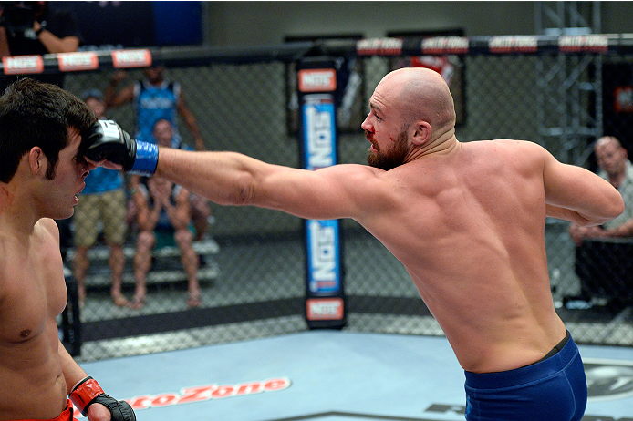 LAS VEGAS, NV - OCTOBER 24: (R-L) Team Penn fighter Cathal Pendred punches Team Edgar fighter Hector Urbina in their preliminary fight during filming of season nineteen of The Ultimate Fighter on October 24, 2013 in Las Vegas, Nevada. (Photo by Jeff Bott