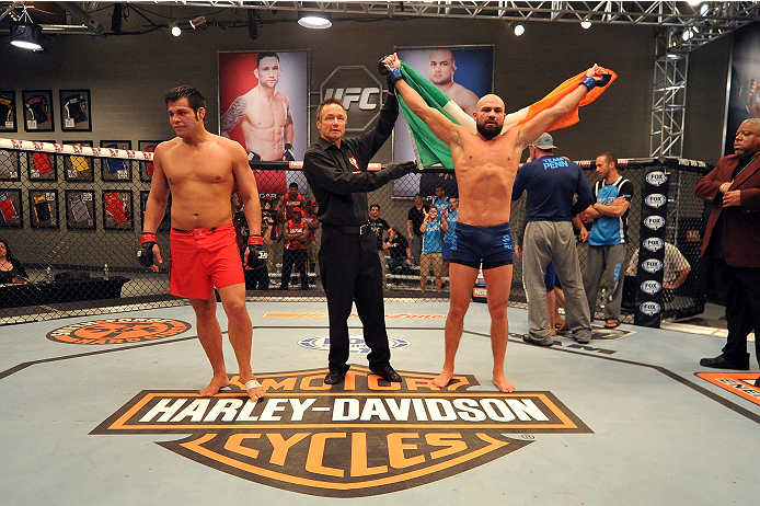 LAS VEGAS, NV - OCTOBER 24: (R-L) Team Penn fighter Cathal Pendred celebrates after defeating Team Edgar fighter Hector Urbina in their preliminary fight during filming of season nineteen of The Ultimate Fighter on October 24, 2013 in Las Vegas, Nevada.
