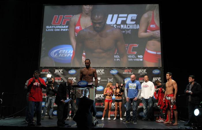 TORONTO, ON - DECEMBER 09: UFC Light Heavyweight Champion Jon "Bones" Jones weighs in as opponent Lyoto Machida (red shorts) looks on during the UFC 140 Official Weigh-in at the Air Canada Centre on December 9, 2011 in Toronto, Canada. (Photo by Josh He