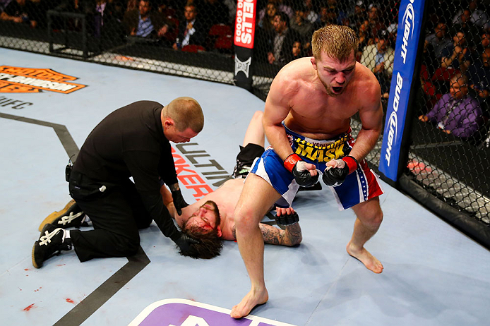 NEWARK, NJ - APRIL 27: Bryan Caraway (R) celebrates winning by submission (guillotine choke) against Johnny Bedford (C) in their bantamweight bout during the UFC 159 event at the Prudential Center on April 27, 2013 in Newark, New Jersey. (Photo by Al Be