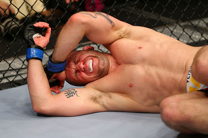 NEWARK, NJ - APRIL 27: Alan Belcher reacts after being poked in the eye in the third round of his middleweight bout against Michael Bisping of England during the UFC 159 event at the Prudential Center on April 27, 2013 in Newark, New Jersey. (Photo by A