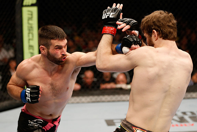 WINNIPEG, CANADA - JUNE 15: (L-R) John Maguire punches Mitch Clarke in their lightweight fight during the UFC 161 event at the MTS Centre on June 15, 2013 in Winnipeg, Manitoba, Canada. (Photo by Josh Hedges/Zuffa LLC/Zuffa LLC via Getty Images)