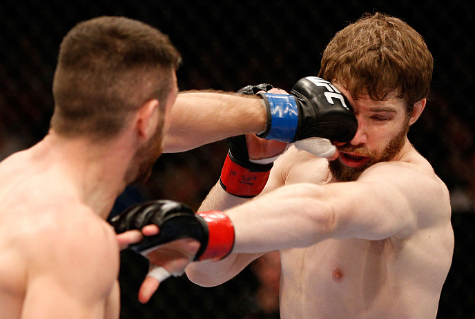 WINNIPEG, CANADA - JUNE 15: (L-R) John Maguire punches Mitch Clarke in their lightweight fight during the UFC 161 event at the MTS Centre on June 15, 2013 in Winnipeg, Manitoba, Canada. (Photo by Josh Hedges/Zuffa LLC/Zuffa LLC via Getty Images)