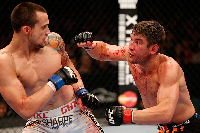 WINNIPEG, CANADA - JUNE 15: (R-L) Sam Stout punches James Krause in their lightweight fight during the UFC 161 event at the MTS Centre on June 15, 2013 in Winnipeg, Manitoba, Canada. (Photo by Josh Hedges/Zuffa LLC/Zuffa LLC via Getty Images)