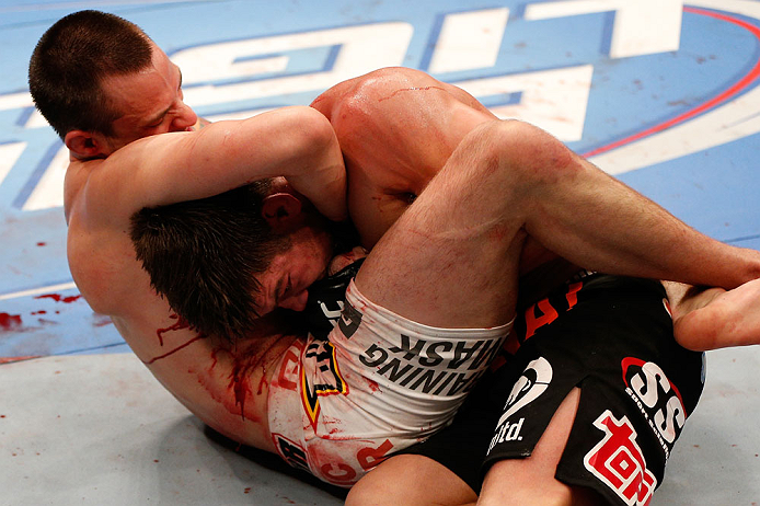 WINNIPEG, CANADA - JUNE 15: (L-R) James Krause secures a guillotine choke submission against Sam Stout in their lightweight fight during the UFC 161 event at the MTS Centre on June 15, 2013 in Winnipeg, Manitoba, Canada. (Photo by Josh Hedges/Zuffa LLC/