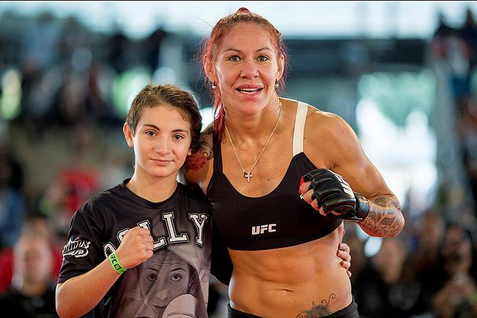 RIO DE JANEIRO, BRAZIL - MAY 11: Catchweight Cris "Cyborg Justino of Brazil poses for a photo with a fan during an open training session at Arena da Baixada stadium on May 11, 2016 in Curitiba, Brazil. (Photo by Buda Mendes/Zuffa LLC/Zuffa LLC via Getty I