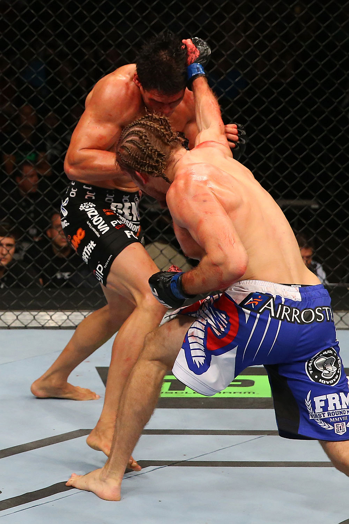 SAN ANTONIO, TX - JUNE 28: Andrew Craig (blue shorts) punches Cezar Ferreira in their middleweight bout at the AT&T Center on June 28, 2014 in San Antonio, Texas. (Photo by Ed Mulholland/Zuffa LLC/Zuffa LLC via Getty Images)