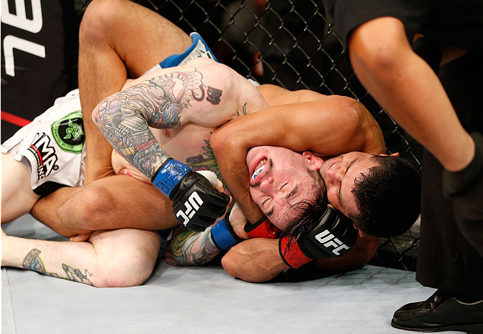 NATAL, BRAZIL - MARCH 23: (R-L) Jussier Formiga secures a rear choke submission against Scott Jorgensen in their flyweight bout during the UFC Fight Night event at Ginasio Nelio Dias on March 23, 2014 in Natal, Brazil. (Photo by Josh Hedges/Zuffa LLC/Zuf