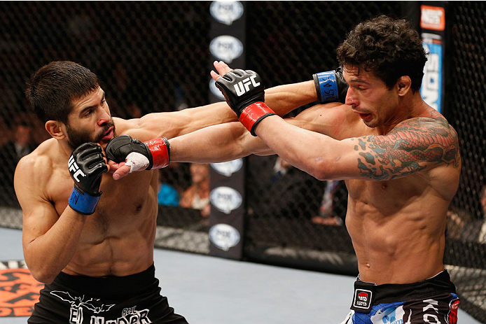 LAS VEGAS, NV - JULY 06: (L-R) Juan Maneul Puig Carreon exchanges punches with Adriano Martins in their lightweight fight during the Ultimate Fighter Finale inside the Mandalay Bay Events Center on July 6, 2014 in Las Vegas, Nevada. (Photo by Josh Hedge