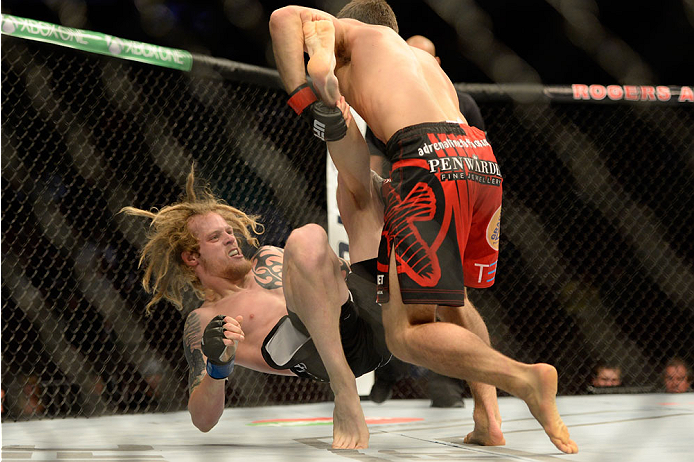 VANCOUVER, BC - JUNE 14: (R-L) Jason Saggo takes down Josh Shockley during the UFC 174 event at Rogers Arena on June 14, 2014 in Vancouver, British Columbia, Canada. (Photo by Jeff Bottari/Zuffa LLC/Zuffa LLC via Getty Images)