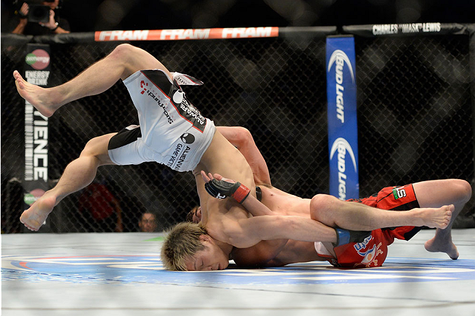 VANCOUVER, BC - JUNE 14: (L-R) Michinori Tanaka is flipped over by Roland Delorme during the UFC 174 event at Rogers Arena on June 14, 2014 in Vancouver, British Columbia, Canada. (Photo by Jeff Bottari/Zuffa LLC/Zuffa LLC via Getty Images)