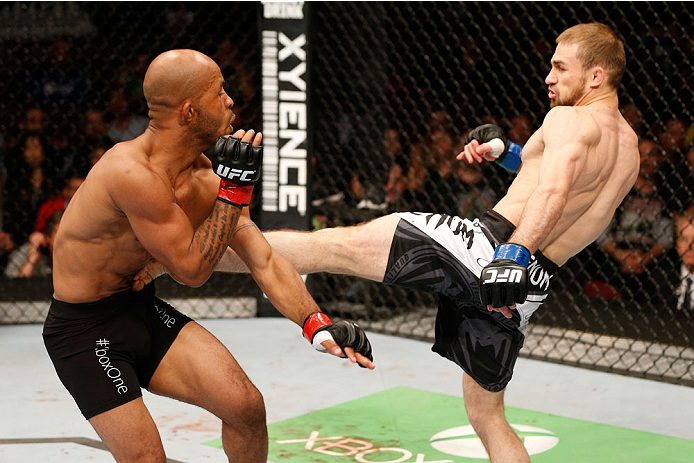 VANCOUVER, BC - JUNE 14: (R-L) Ali Bagautinov kicks Demtrious 'Mighty Mouse' Johnson in their UFC flyweight championship bout at Rogers Arena on June 14, 2014 in Vancouver, Canada. (Photo by Josh Hedges/Zuffa LLC/Zuffa LLC via Getty Images)