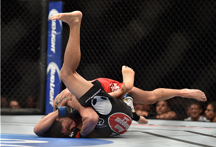LAS VEGAS, NV - SEPTEMBER 27: (Top) Dominick Cruz takes down Takeya Mizugaki in their bantamweight fight during the UFC 178 event inside the MGM Grand Garden Arena on September 27, 2014 in Las Vegas, Nevada. (Photo by Jeff Bottari/Zuffa LLC/Zuffa LLC vi