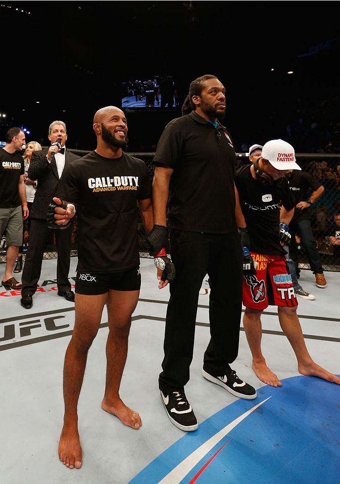 LAS VEGAS, NV - SEPTEMBER 27: (L-R)UFC Flyweight champion Demetrious Johnson celebrates after his win over Chris Cariaso after their flyweight championship fight during the UFC 178 event inside the MGM Grand Garden Arena on September 27, 2014 in Las Vega