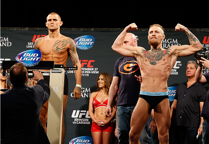 LAS VEGAS, NV - SEPTEMBER 26: Dustin Poirier (L) stands on the scale attempting to make weight before his fight against Conor McGregor (R) of Ireland during the UFC 178 weigh-in at the MGM Grand Conference Center on September 26, 2014 in Las Vegas, Nevad