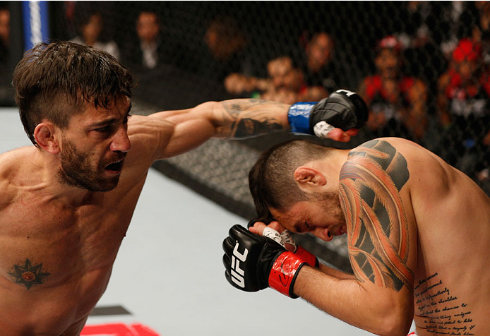 MEXICO CITY, MEXICO - NOVEMBER 15: (L-R) Guido Cannetti punches Henry Briones in their bantamweight bout during the UFC 180 event at Arena Ciudad de Mexico on November 15, 2014 in Mexico City, Mexico. (Photo by Josh Hedges/Zuffa LLC/Zuffa LLC via Getty