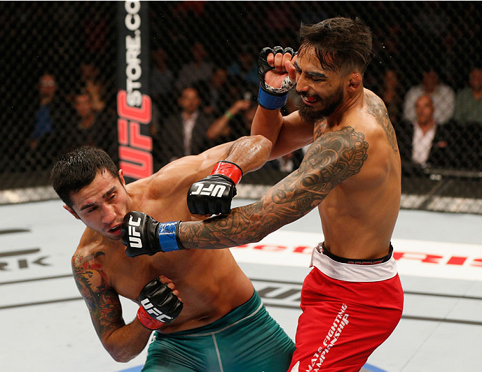 MEXICO CITY, MEXICO - NOVEMBER 15: (L-R) Alejandro Perez punches Jose Quinonez in their bantamweight bout during the UFC 180 event at Arena Ciudad de Mexico on November 15, 2014 in Mexico City, Mexico. (Photo by Josh Hedges/Zuffa LLC/Zuffa LLC via Getty