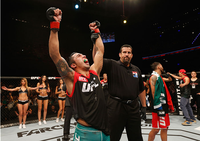 MEXICO CITY, MEXICO - NOVEMBER 15: (L-R) Alejandro Perez celebrates his victory over Jose Quinonez in their bantamweight bout during the UFC 180 event at Arena Ciudad de Mexico on November 15, 2014 in Mexico City, Mexico. (Photo by Josh Hedges/Zuffa LLC