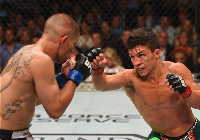 LAS VEGAS, NV - MAY 23: (R-L) Joseph Benavidez punches John Moraga in their flyweight bout during the UFC 187 event at the MGM Grand Garden Arena on May 23, 2015 in Las Vegas, Nevada. (Photo by Josh Hedges/Zuffa LLC/Zuffa LLC via Getty Images)