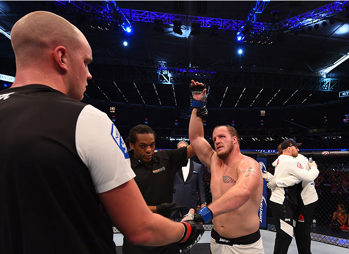 MELBOURNE, AUSTRALIA - NOVEMBER 15: Referee Herb Dean (C) announces Jared Rosholt (R) winner by Unanimous Decision over Stefan Struve (L) in their heavyweight bout during the UFC 193 event at Etihad Stadium on November 15, 2015 in Melbourne, Australia.