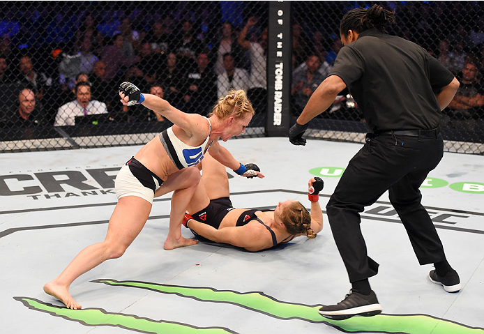 MELBOURNE, AUSTRALIA - NOVEMBER 15: Holly Holm (L) punches Ronda Rousey (C) in the second round of their UFC women's bantamweight championship bout as referee Herb Dean (R) looks on during the UFC 193 event at Etihad Stadium on November 15, 2015 in Melbo