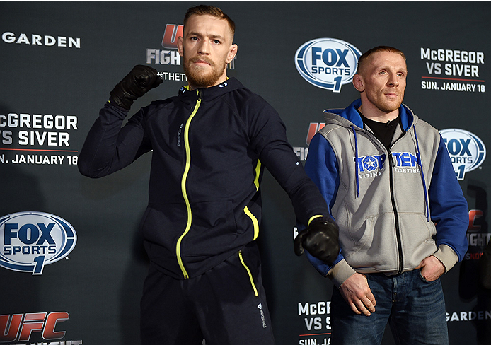 BOSTON, MA - JANUARY 16: UFC featherweights Conor McGregor of Ireland (L) and Dennis Siver of Germany interact with media at Faneuil Hall on January 16, 2015 in Boston, Massachusetts. (Photo by Jeff Bottari/Zuffa LLC/Zuffa LLC via Getty Images)