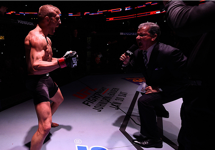 BOSTON, MA - JANUARY 17: TJ Dillashaw (L) is introduced in the Octagon by Bruce Buffer before his UFC bantamweight championship bout against Dominick Cruz during the UFC Fight Night event inside TD Garden on January 17, 2016 in Boston, Massachusetts. (P
