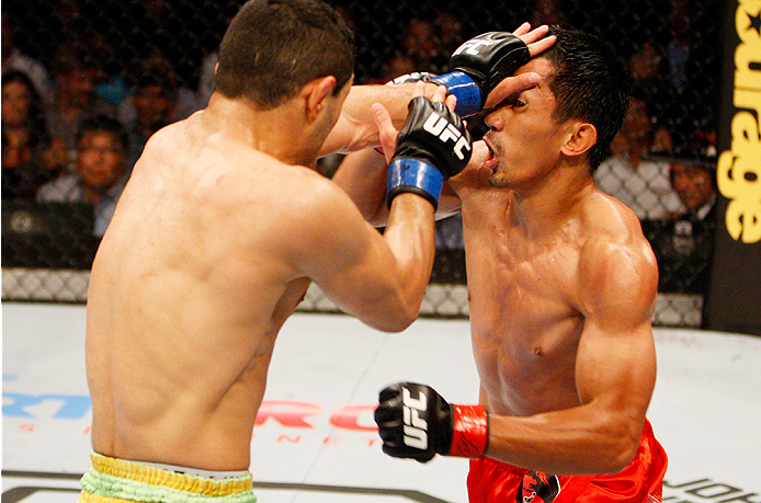 MANILA, PHILIPPINES - MAY 16: (L to R) Levan Makashvili of the United States and Mark Eddiva of the Philippines exchange punches in their featherweight fight during the UFC Fight Night event at the Mall of Asia Arena on May 16, 2015 in Manila, Philippine