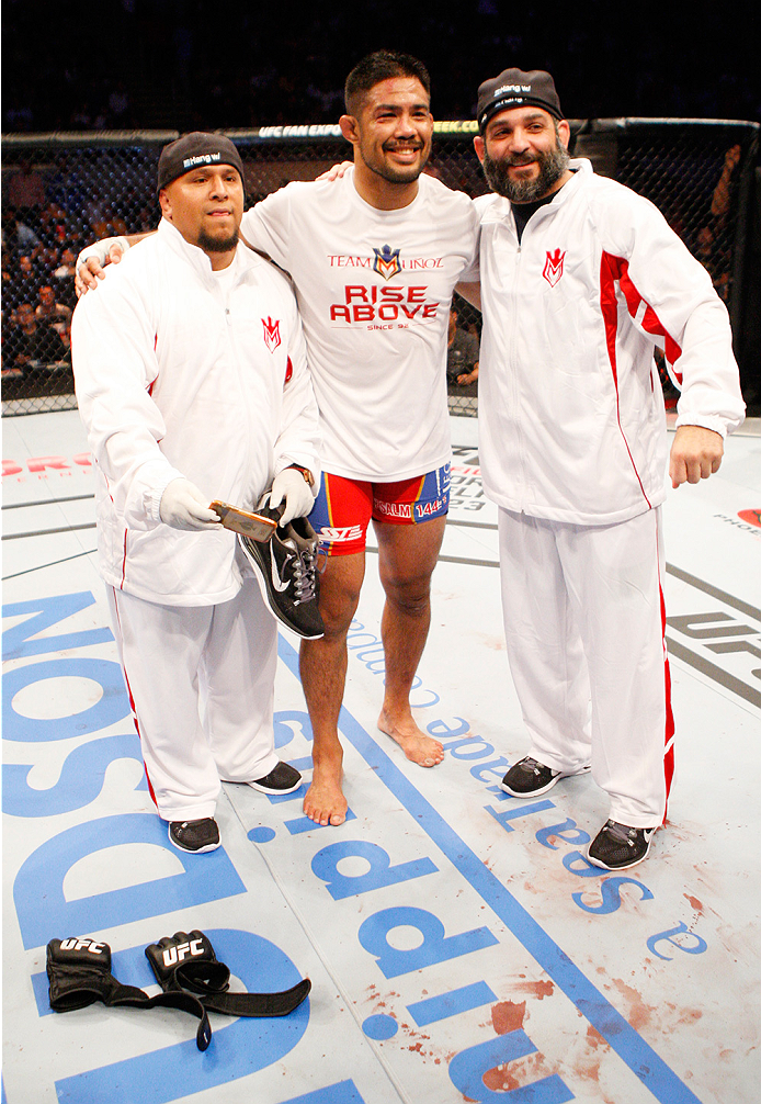 MANILA, PHILIPPINES - MAY 16: Mark Munoz of the United States with his team after his win and retirement from the UFC, leaving his gloves in the middle of the octagon during the UFC Fight Night event at the Mall of Asia Arena on May 16, 2015 in Manila, Ph