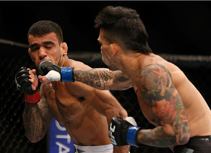 SINGAPORE - JANUARY 04: (R-L) Russell Doane punches Leandro Issa in their bantamweight bout during the UFC Fight Night event at the Marina Bay Sands Resort on January 4, 2014 in Singapore. (Photo by Josh Hedges/Zuffa LLC/Zuffa LLC via Getty Images)