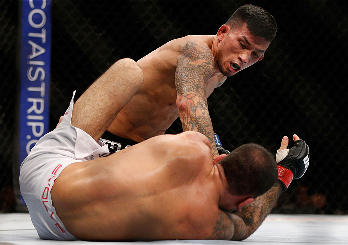 SINGAPORE - JANUARY 04: (L-R) Russell Doane punches Leandro Issa in their bantamweight bout during the UFC Fight Night event at the Marina Bay Sands Resort on January 4, 2014 in Singapore. (Photo by Josh Hedges/Zuffa LLC/Zuffa LLC via Getty Images)