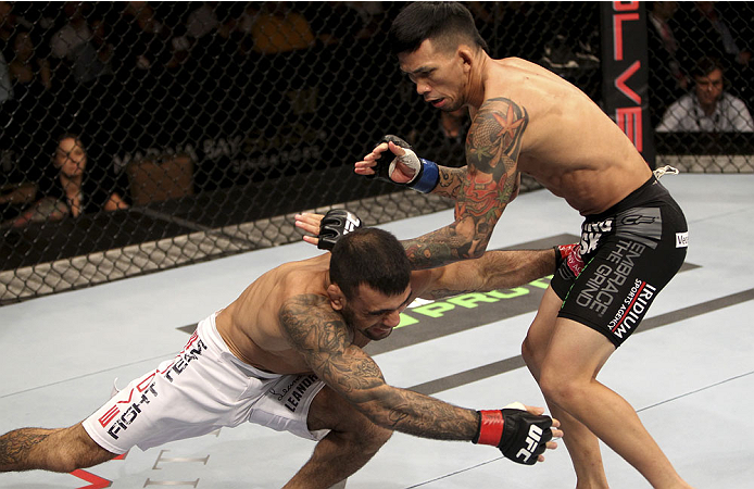 SINGAPORE - JANUARY 04: (L to R) Leandro Issa goes for a take down against Russell Doane in their bantamweight bout during the UFC Fight Night event at the Marina Bay Sands Resort on January 4, 2014 in Singapore. (Photo by Mitch Viquez/Zuffa LLC/Zuffa LLC
