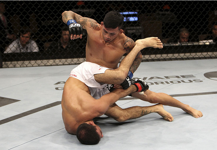 SINGAPORE - JANUARY 04: Russell Doane lays down punches on Leandro Issa in their bantamweight bout during the UFC Fight Night event at the Marina Bay Sands Resort on January 4, 2014 in Singapore. (Photo by Mitch Viquez/Zuffa LLC/Zuffa LLC via Getty Image