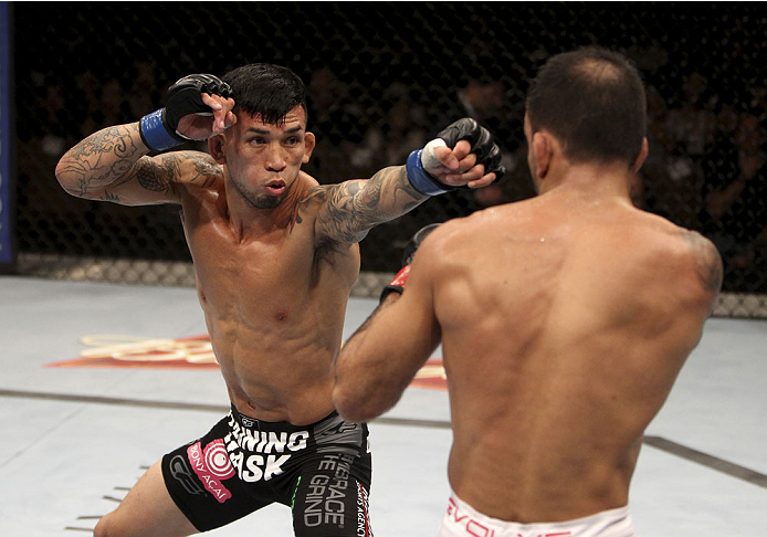 SINGAPORE - JANUARY 04: Russell Doane goes for a shot on Leandro Issa in their bantamweight bout during the UFC Fight Night event at the Marina Bay Sands Resort on January 4, 2014 in Singapore. (Photo by Mitch Viquez/Zuffa LLC/Zuffa LLC via Getty Images)