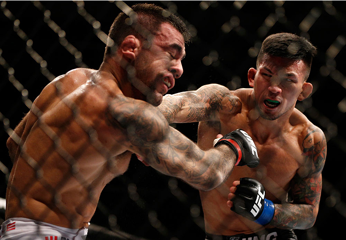 SINGAPORE - JANUARY 04: (R-L) Russell Doane punches Leandro Issa in their bantamweight bout during the UFC Fight Night event at the Marina Bay Sands Resort on January 4, 2014 in Singapore. (Photo by Josh Hedges/Zuffa LLC/Zuffa LLC via Getty Images)